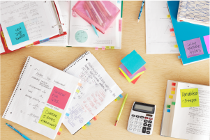 Cuadernos con notas, calculadora y lápiz amarillo.
